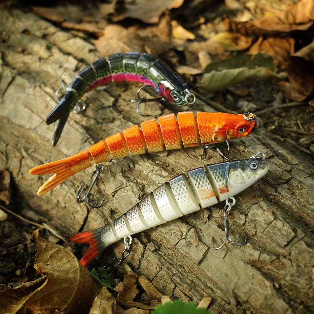 Three colorful fishing lures on a textured surface with leaves